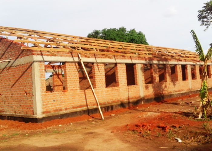 Brick building under construction with roof trusses in place